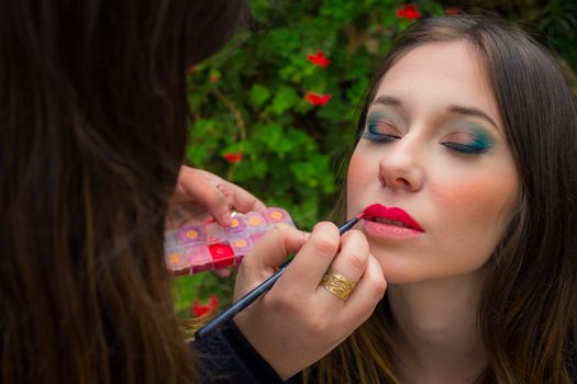 Professional make up artist doing glamour model makeup at work.