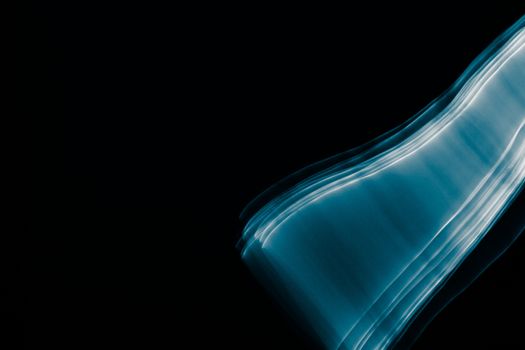 Light painted glowing abstract blue and white curved lines on a black background