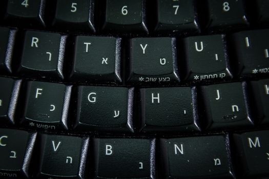 Keyboard with letters in Hebrew and English - Wireless keyboard - Top View - Close up - Dark atmosphere