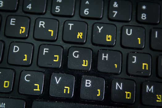 Keyboard with letters in Hebrew and English - Laptop keyboard - Top View - Close up - Dark atmosphere