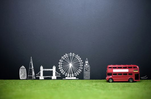 London landmarks drawn on a blackboard with a double decker bus on a grass lawn