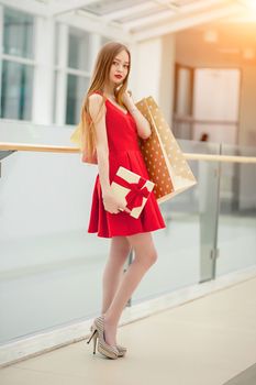 Beautiful smiling woman with long hair holding gift box
