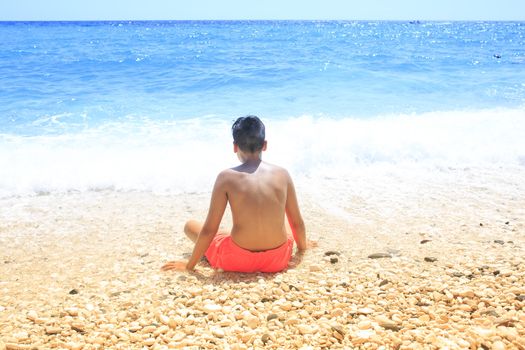 Boy sitting on the beach