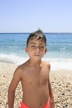 Boy with beautiful green eyes on the beach