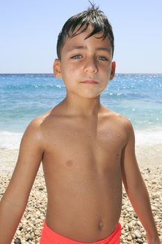 Boy with beautiful green eyes on the beach