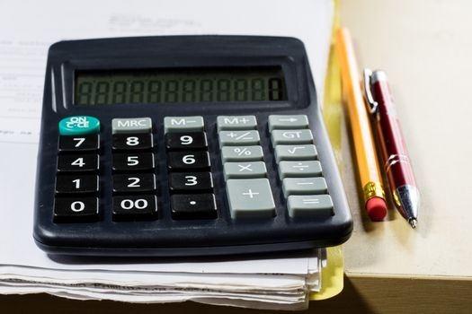 Bills, documents and papers with calculator. Office of the accounting office. Wooden table.