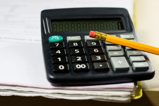 Bills, documents and papers with calculator. Office of the accounting office. Wooden table.