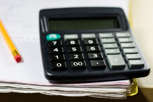 Bills, documents and papers with calculator. Office of the accounting office. Wooden table.