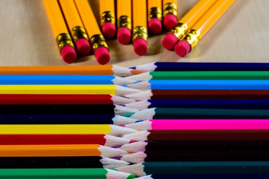 Beautiful and colorful pencil crayons. Wooden table. Black background.