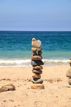 Stones piled on top of one another in Inuksuk fashion in summer at the San Clemente State Beach in Southern California