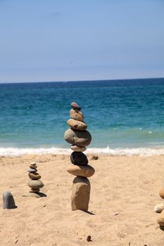 Stones piled on top of one another in Inuksuk fashion in summer at the San Clemente State Beach in Southern California