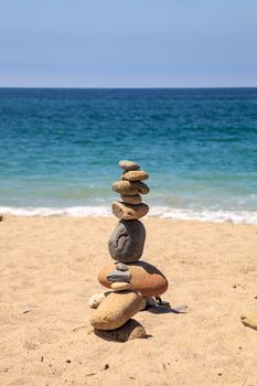 Stones piled on top of one another in Inuksuk fashion in summer at the San Clemente State Beach in Southern California