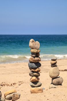 Stones piled on top of one another in Inuksuk fashion in summer at the San Clemente State Beach in Southern California