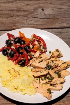 Spicy Chicken Diablo with cilantro, olives, peppers, garlic and onion served over saffron yellow rice.