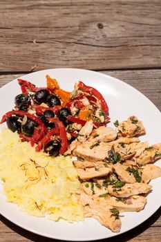 Spicy Chicken Diablo with cilantro, olives, peppers, garlic and onion served over saffron yellow rice.