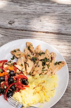 Spicy Chicken Diablo with cilantro, olives, peppers, garlic and onion served over saffron yellow rice.