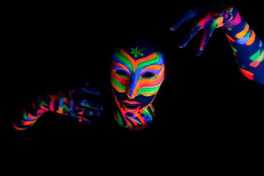 Woman with make up art of glowing UV fluorescent powder.