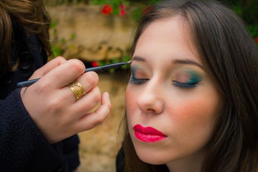 Professional make up artist doing glamour model makeup at work.