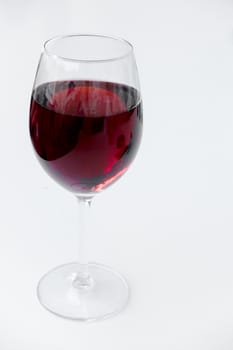 Red wine in a glass isolated on white background - realistic photo image, shot from slightly above