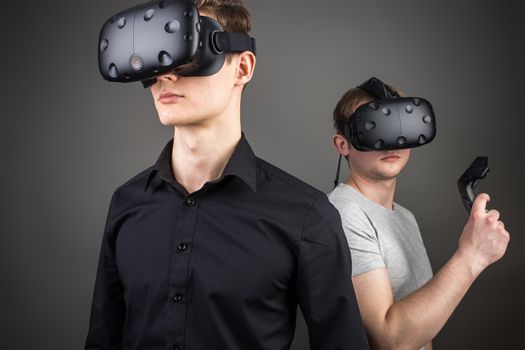 two young man playing game using virtual reality headset