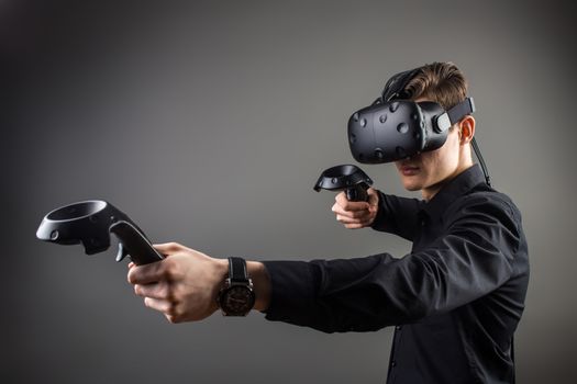 young man playing games with virtual reality goggles