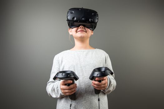 Child with virtual reality headset and joystick playing video games