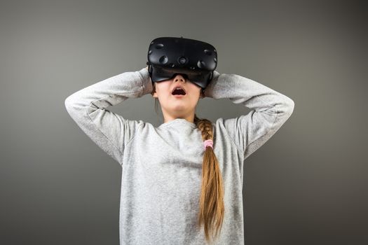 surprised little girl using a virtual reality headset