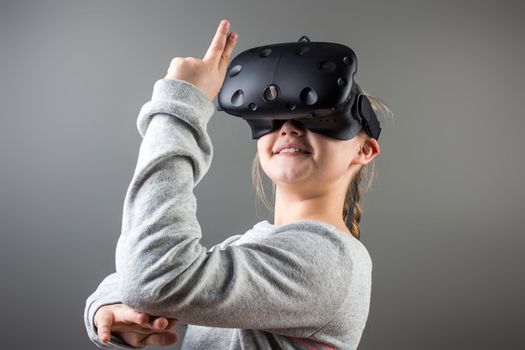 Happy little girl using a virtual reality headset