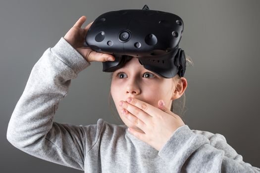 surprised little girl using a virtual reality headset