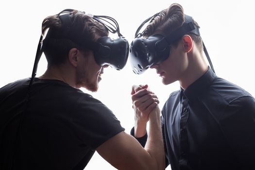 Shot of two young man standing with VR goggles. Developers testing virtual reality glasses