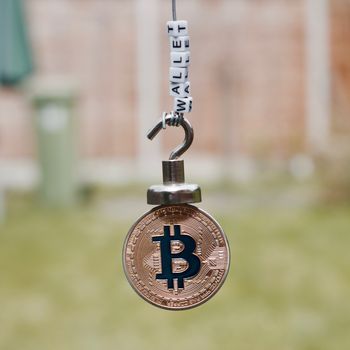 Digital currency physical metal bitcoin coin on the magnet with wallet inscription.