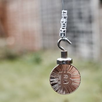 Digital currency physical metal bitcoin coin on the magnet with wallet inscription.