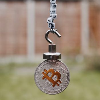 Digital currency physical metal bitcoin coin on the magnet with wallet inscription.