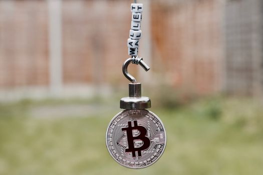 Digital currency physical metal bitcoin coin on the magnet with wallet inscription.
