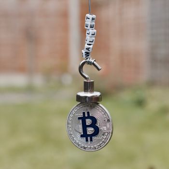 Digital currency physical metal bitcoin coin on the magnet with wallet inscription.