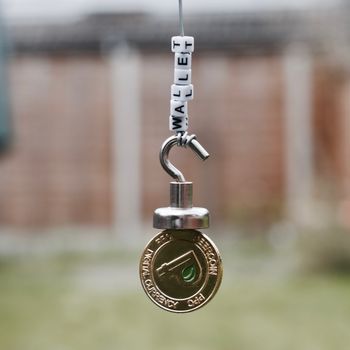 Digital currency physical gold peercoin coin near wallet inscription on the hook.