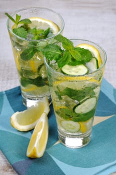 Refreshing cocktail cucumber mojito with lemon slices and mint