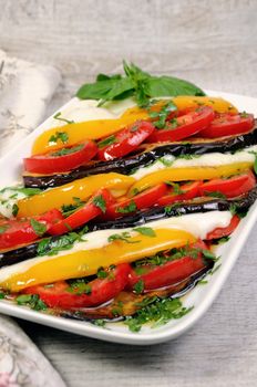 Baked eggplants with tomatoes, yellow pepper and slices  mozzarella 