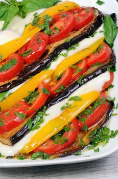 Baked eggplants with tomatoes, yellow pepper and slices  mozzarella 