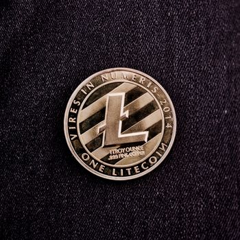 Digital currency physical metal litecoin coin. Virtual cash concept.