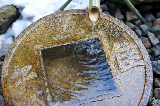 Close up on traditional ritual washing basin at the Ryoan-Ji Tsukubai temple in Japan