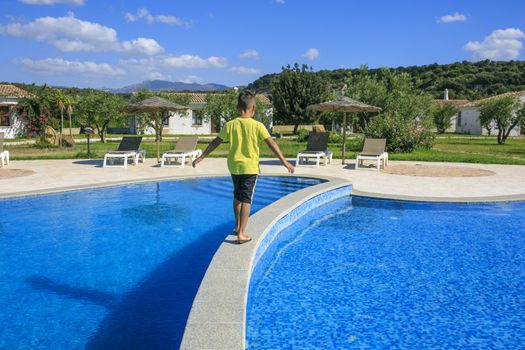 Boy  walking over the swimming pool