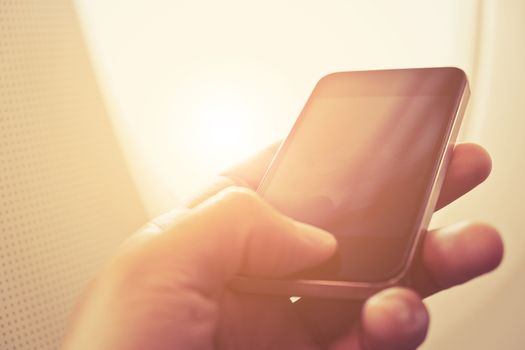 close up of business man sit in airplane watching his cell phone, Doing business the modern way concept background