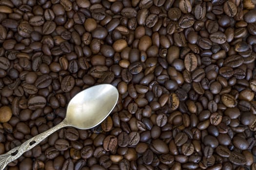 silver spoon in the corner and coffee beans as the background