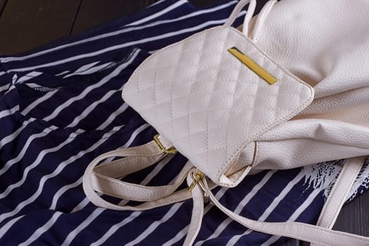 White Leather Women's Backpack on a Striped T-shirt