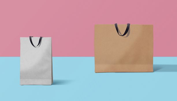 Two paper bags for shopping on a pink background