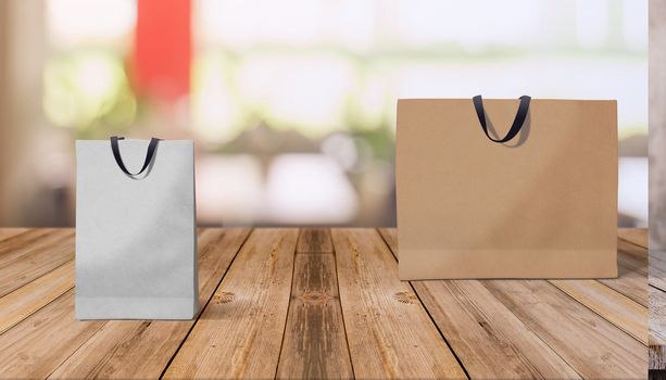 Two paper bags for shopping on a wooden background