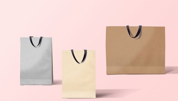 three paper bags for shopping on a pink background