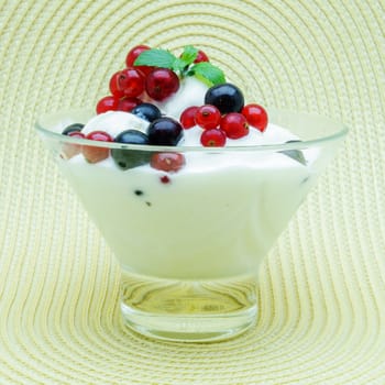 Glass vase with ice cream decorated with black and red currant