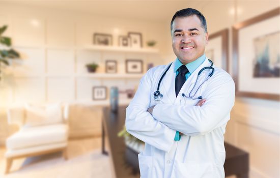 Handsome Hispanic Doctor or Nurse Standing in His Office.